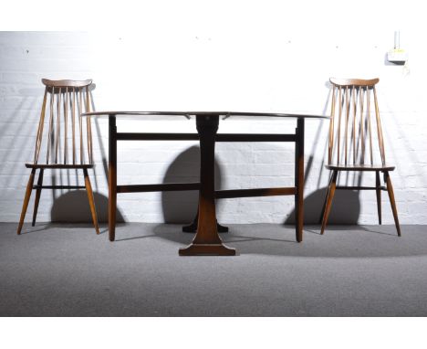 Ercol oval drop leaf dining table, and four stick back chairs, width 129cm.