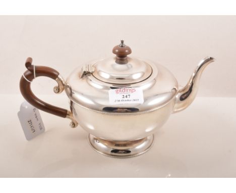Three piece silver tea set, Birmingham 1931, circular pedestal form, beaded outlines, tea pot with wooden handle and finial, 