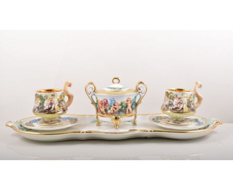 Capodimonte cabaret set, moulded and painted decoration, comprising two cups and saucers and sucrier on a tray, width 45cm. 