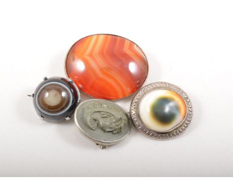 White metal mounted agate brooches, a lava cameo brooch and a white metal Fossil shell brooch.