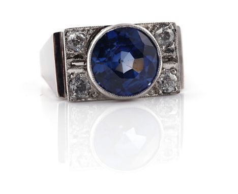 A SAPPHIRE AND DIAMOND RINGCollet set with the circular cut sapphire between diamond set two stone sides, mounted with cushio