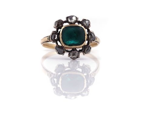 A DIAMOND AND GREEN PASTE CLUSTER RINGMounted with a foil backed green paste at the centre, in an openwork surround mounted w