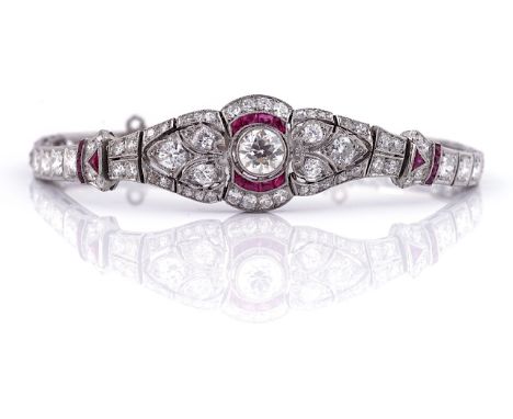 AN ART DECO STYLE DIAMOND AND RUBY SET THITE PRECIOUS METAL BRACELETOf openwork tapered link design, the central panel set wi
