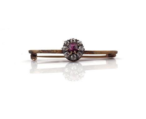 A RUBY AND DIAMOND CLUSTER BAR BROOCHClaw set with the oval cut ruby at the centre within a surround of eight cushion shaped 