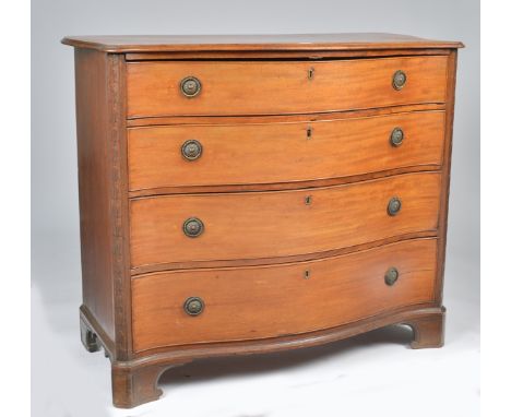 A GEORGE III MAHOGANY SERPENTINE CHESTWith four long graduated drawers flanked by bell flower carved canted corners, the top 