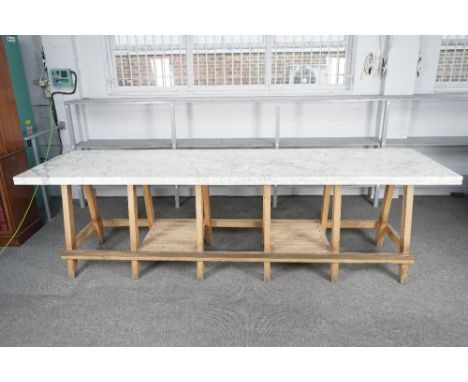 A LARGE OUTSIDE KITCHEN-BARWith rectangular marble top on twelve oak supports united by brass capped stretcher 90cm wide; 325