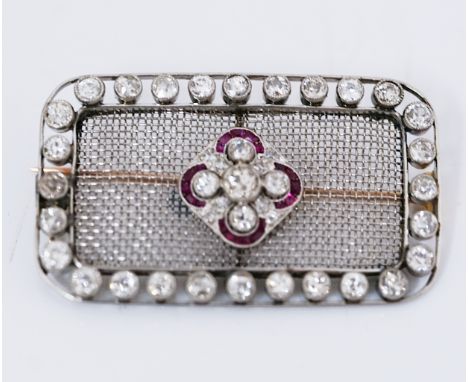 A DIAMOND AND RUBY BROOCHOf rectangular form, the centre mounted with five principal cushion shaped diamonds and otherwise se