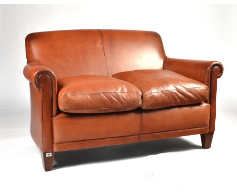 LAURA ASHLEY; A SMALL TAN LEATHER TWO SEAT SOFAOn tapering block supports; 132cm wide x 82cm highCondition report:&nbsp;Good 