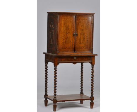 A SMALL VICTORIAN WALNUT PENWORK DECORATED CABINET ON STANDThe pair of doors revealing an architectural fitted interior, on b