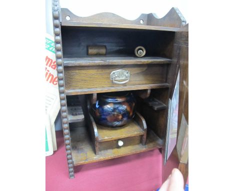 An Early XX Century Oak Smokers Cabinet, with diamond shaped glazed door, internal drawers, mixing bowl (dam) and pipe.