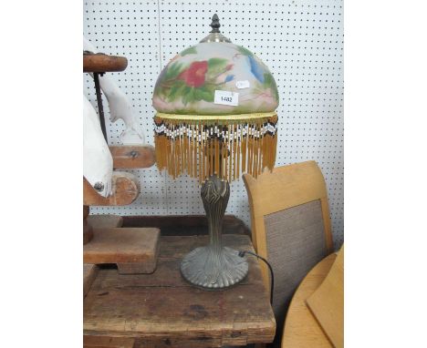 An Art Nouveau Style Table Lamp, with painted glass shade, bead drops on a circular reeded base, 55m high.