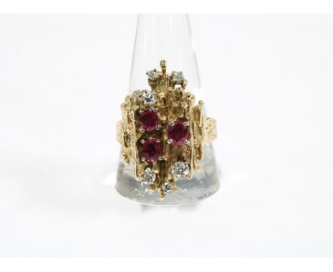 Vintage 9ct gold ruby and diamond dress ring, London 1972, with three oval rubies and six diamonds, in a textured abstract se