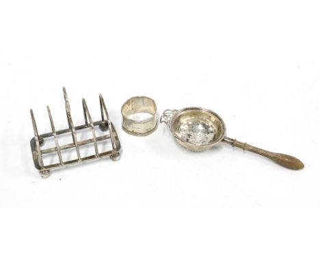 George V silver toast rack London 1914, Birmingham silver tea strainer and a silver napkin ring (3) 