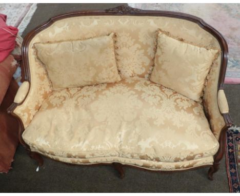A 20th century French carved walnut two seater sofa, upholstered in gold damask silk and with a pair of throw pillows, 132cm 