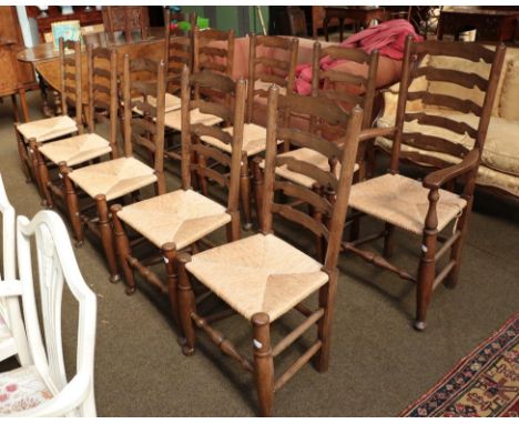A set of ten oak ladder back dining chairs with rush seats, including a pair of carver chairs .  Some play in the joints, a c