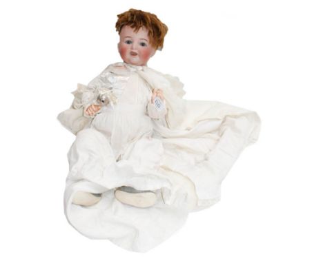 A Simon &amp; Halbig 126 doll in a white cotton dress, together with a silver and mother of pearl teether, and a silver part 