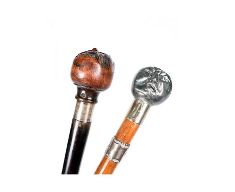 Two vintage walking canes, one having carved wooden face of elderly man, white metal collar and hardwood shaft, top unscrews 