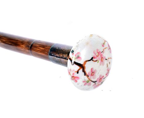A ceramic topped walking cane, the pebble shaped pearlescent coloured top, with had painted floral design, possibly cherry bl