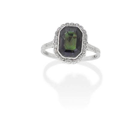 ALEXANDRITE AND DIAMOND RING, CIRCA 1920The octagonal step-cut alexandrite within a surround of single-cut diamonds, the shou