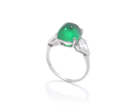 JANESICH: ART DECO EMERALD AND DIAMOND RING, CIRCA 1920The sugarloaf cabochon emerald, weighing 3.52 carats, between pentagon