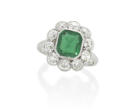 CARTIER: EMERALD AND DIAMOND CLUSTER RING, CIRCA 1930The octagonal step-cut emerald within a surround of old brilliant-cut di