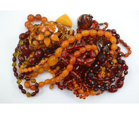 A quantity of amber and amber type necklaces, together with bracelets, brooches, ring and pendant