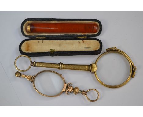 A pair of engine turned yellow metal lunettes, and a similar smaller pair along with a cheroot holder with yellow metal colla