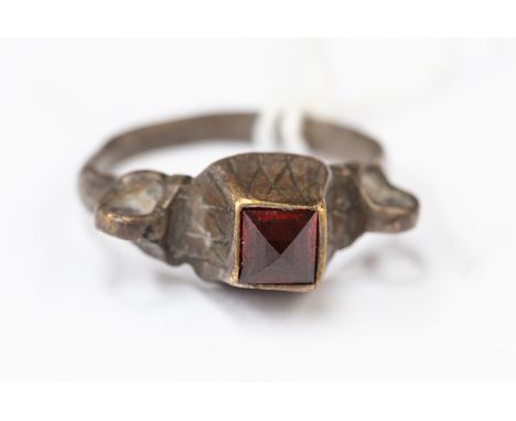 Byzantine (10th-12th century AD) A silver ring with plain band, openwork loops to the shoulder; square bezel with engraved ne