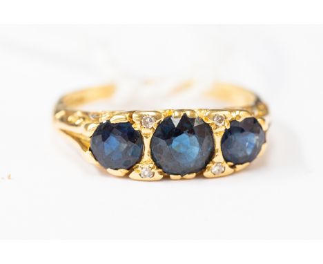 A Victorian sapphire and diamond ring, comprising three round sapphires, with diamond accents, 18 ct gold, size K, total gros