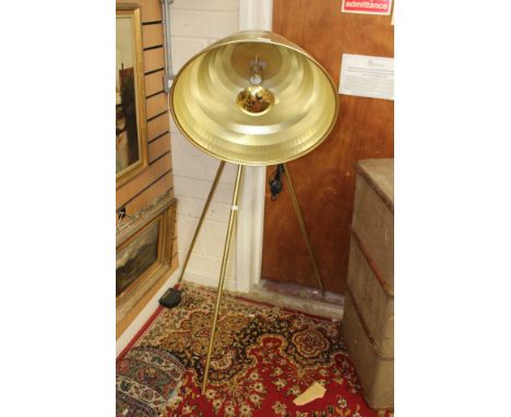 A large metallic studio style tripod lamp.