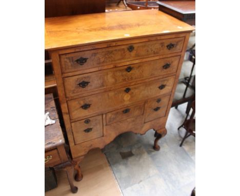 A first quarter 20th century Georgian style reproduction mahogany and walnut chest of drawers.