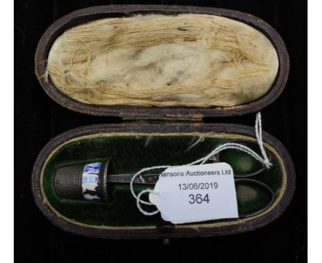 A Victorian pair of white metal scissors complete with a white metal thimble fitted in the original leather case