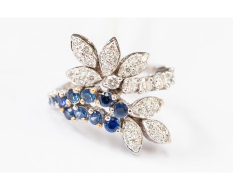 A diamond and sapphire fancy cluster,18 ct white gold ring, stylized leaf and scroll design, pave and claw set with round bri