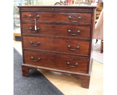A George III mahogany chest of drawers, fitted with a brushing slide over four long graduated drawers, retaining original han