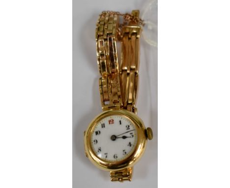 An early 20th Century 18ct gold cased lady's wristwatch, engraved to reverse,  on yellow metal link bracelet stamped 9ct, rou