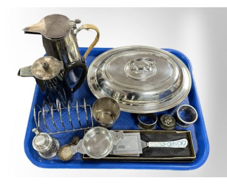 A silver plated lidded entree dish, two jugs, toast rack, stamp box, napkin rings, caddy spoon etc 