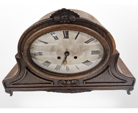 A 1920s carved oak bracket clock with pendulum and key, striking on a gong, width 49cm.