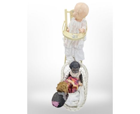 A wicker doll's hamper and dolls, together with a high chair.