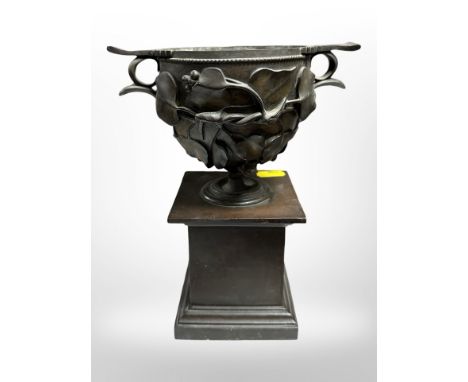 A cast-bronze urn on pedestal, height 21cm.