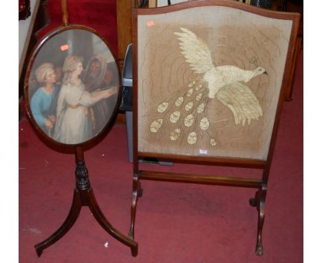 An Edwardian mahogany framed and embroidered fire screen, together with a further 19th century mahogany oval pole screen (2)