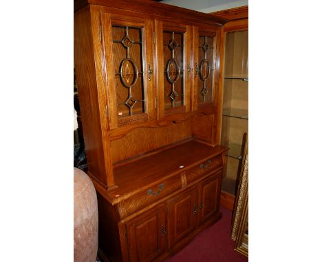 A contemporary oak and lead glazed dresser, the three upper doors over base fitted with twin frieze drawers, to further reces