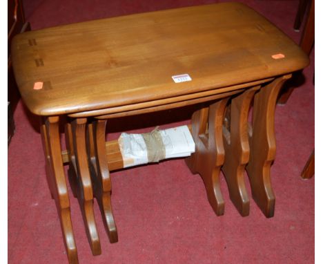 An Ercol mid-elm nest of three occasional tables, the largest w.57cm
