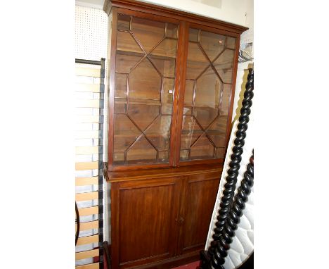 A 19th century mahogany bookcase cupboard, the twin astragal door glazed upper section enclosing adjustable shelves, over bas