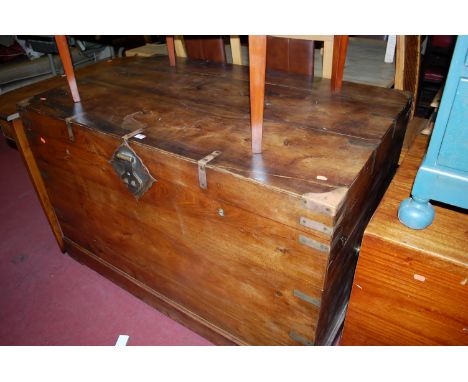A large Indonesian indigenous hardwood and brass bound campaign type hinge top travelling trunk having brass end carry handle