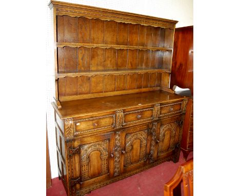 A good 17th century style carved and joined oak dresser, having two-tier open plate-rack over base fitted with three frieze d