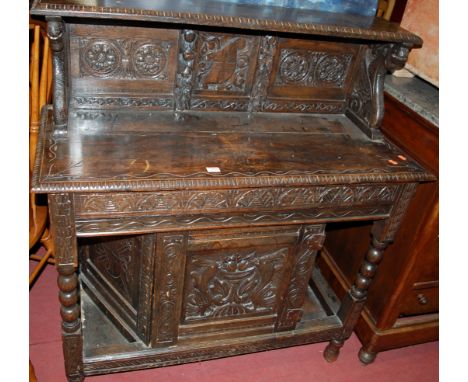 An antique and low relief carved oak buffet side cupboard having raised superstructure, single end drawer, and low central cu