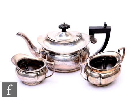 A hallmarked silver three piece boat shape tea set on plain form, total weight 28.5oz, Birmingham 1931, Deykin &amp; Harrison