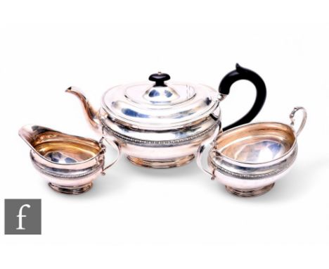 A hallmarked silver three piece boat shaped tea set of plain form with egg and dart detail, total weight 39oz, presentation e