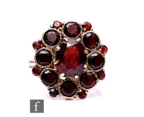 A 9ct hallmarked garnet cluster ring, rope twist collar and claw set stones to an oval head, weight 4.5g, ring size K.