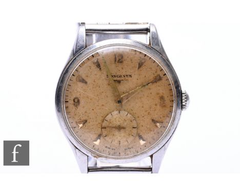 A mid 20th Century Longines stainless steel gentleman's wristwatch, with manual wind movement, the champagne coloured dial wi